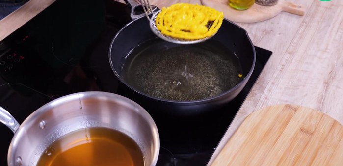 Plongez les zlabias dans du miel tiède, retournez-les plusieurs fois pour bien les imprégner.