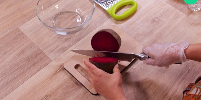 Couper la betterave en deux, râper et mettre des gants pour éviter les mains rouges.