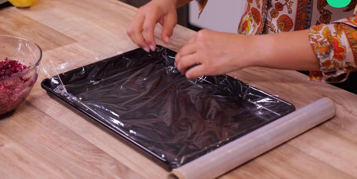 Recouvrir un plat de film alimentaire, étaler la moitié du mélange betterave.