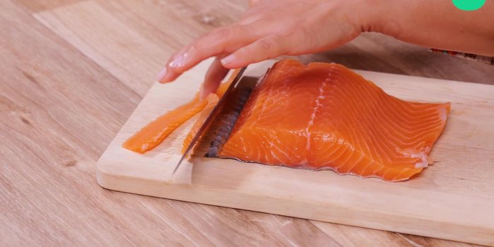 Couper le filet de saumon en fines tranches en évitant la peau.