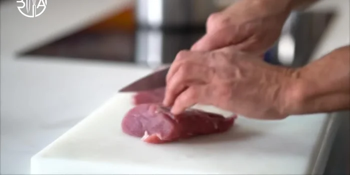 Couper le filet de porc en tranches épaisses et les pétoncles en V. Saisir la viande dans du beurre.