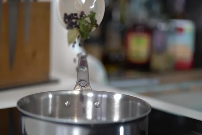 Préparer la sauce : réduire de 2/3 le vin blanc, le vinaigre, les échalotes, les baies de genièvre, les grains de poivre noir et les herbes. Ajouter la peau de poisson fumée et la crème épaisse, puis cuire jusqu'à réduction de moitié. Ajouter le beurre progressivement en fouettant constamment (ne pas faire bouillir, maintenir autour de 50°C).