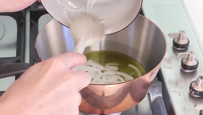 Faire suer les oignons et les carottes dans une poêle avec de l'huile d'olive.