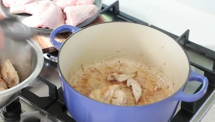 Ajouter les morceaux de poulet et les faire dorer de chaque côté (environ 5 minutes par côté).