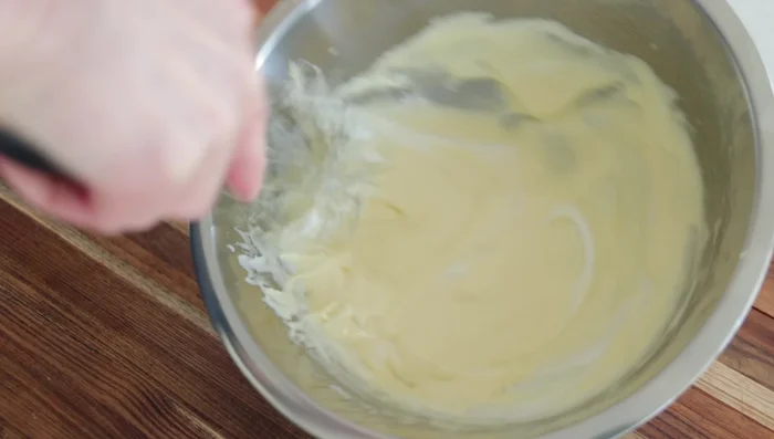 Incorporer délicatement la meringue au mélange aux jaunes d'œufs en utilisant une technique de pliage.