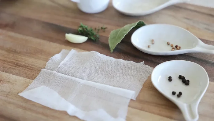 Préparer un petit sac en tissu mousseline (étamine) et y mettre l'ail, les feuilles de laurier, les graines de coriandre et le poivre noir.