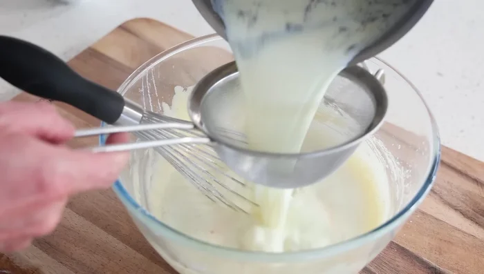 Incorporer progressivement le lait chaud au mélange de jaunes d'œufs et de farine.