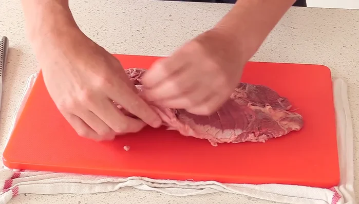 Préparation du steak de hangar : Nettoyer le steak en retirant les excès de peau et les parties de graisse superflues. Détacher délicatement les fibres à l’aide d’un couteau fin et pointu. Séparer les deux steaks.