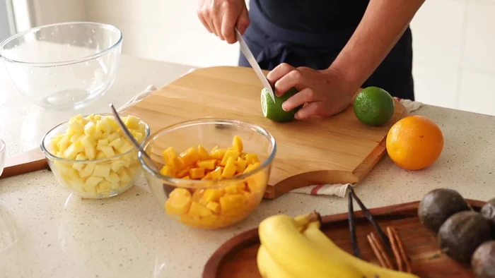 Trancher finement les citrons verts et les oranges.