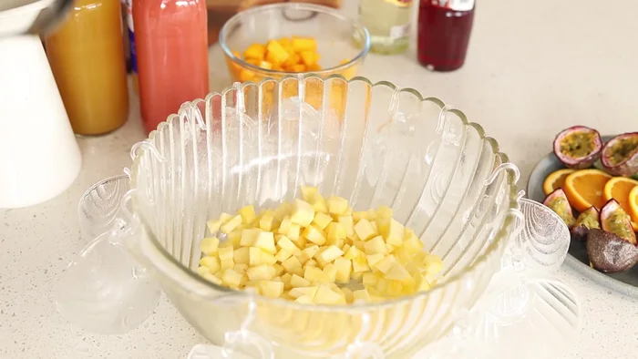 Dans un grand bol, mélanger tous les fruits (ananas, mangue, citron vert, orange, fruit de la passion).