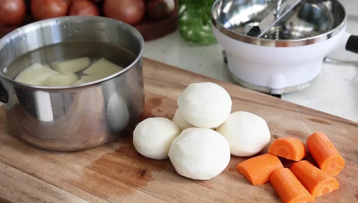 Couper les pommes de terre, les navets et les carottes en morceaux de taille similaire pour une cuisson homogène. (235.36)