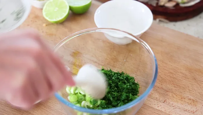 Dans un bol, mettre tous les ingrédients hachés finement : oignon de printemps, persil, piments (Scotch Bonnet ou autre).
