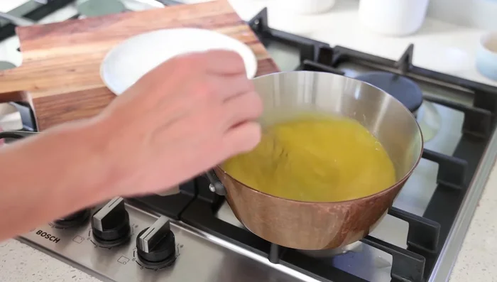 Ajouter le jus de cuisson des moules (environ 300ml). Incorporer le safran (ou curry) préalablement infusé dans un peu de bouillon. Porter à ébullition et laisser réduire 5 minutes en fouettant constamment.