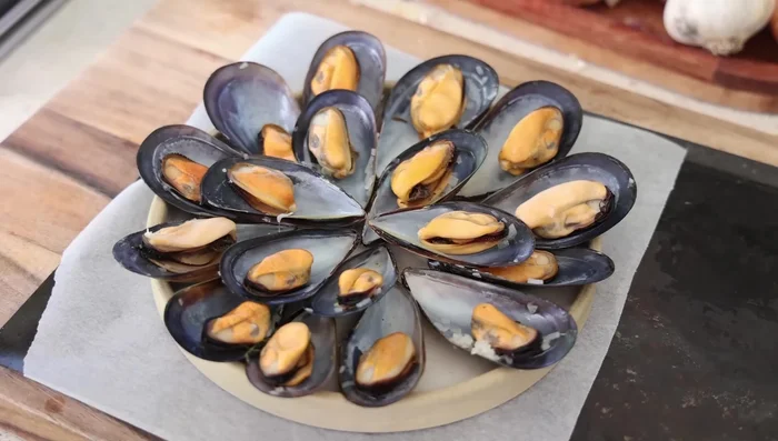 Disposer les moules en cercle sur un plat résistant au four. Verser la sauce sur les moules. Griller 3 minutes pour dorer la sauce.