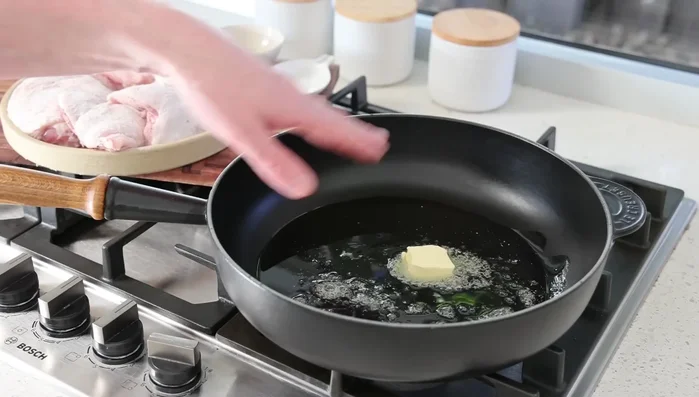 Faire chauffer l'huile d'olive et le beurre dans une sauteuse à feu moyen. Faire dorer le poulet côté peau en premier (environ 5 minutes de chaque côté).