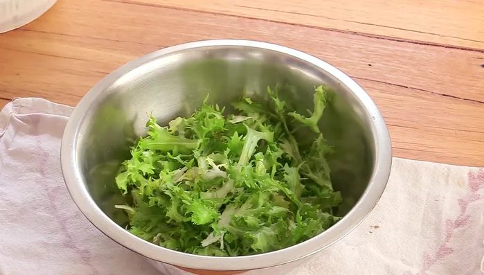 Assembler la salade : Dans un grand bol, mélanger la laitue, la frisée, les lardons, les croûtons et les œufs. Verser la vinaigrette sur la salade et mélanger délicatement. (623.68)