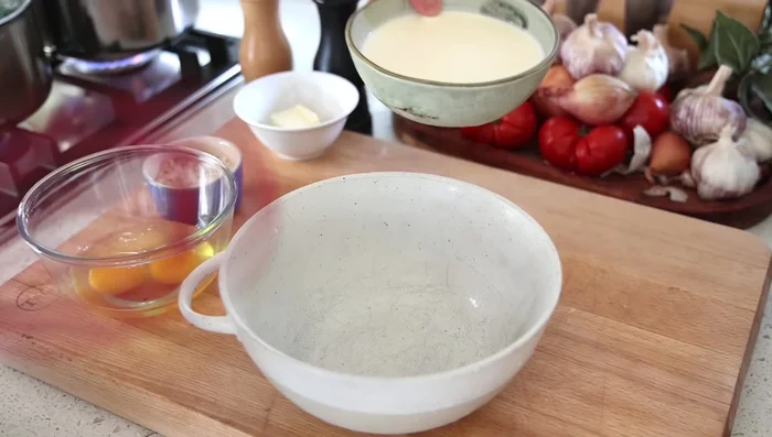 Préparation de la sauce : Dans un bol, fouetter la crème fraîche, les œufs, le lait d'amande, le beurre, le sel et le poivre.