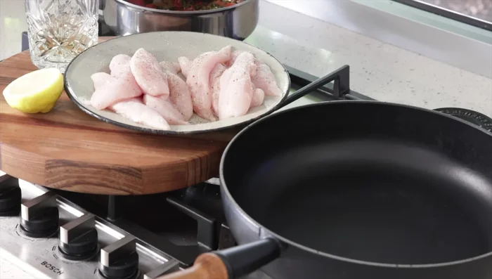 Cuire les filets de poulet : Faire chauffer une poêle en fonte. Paner les filets de poulet dans la farine, saler et poivrer. Cuire les filets de poulet par lots (pour une meilleure coloration) à feu moyen pendant environ 10 minutes, jusqu'à ce qu'ils soient bien colorés.