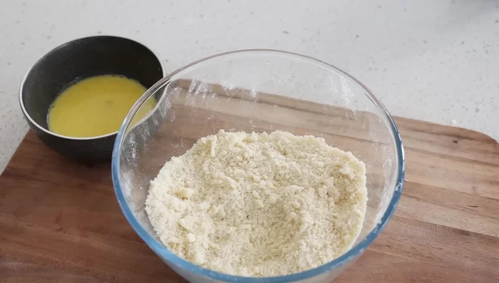 Verser les liquides sur le mélange farine-beurre. Utiliser la spatule pour incorporer les liquides en effectuant un mouvement de hachage de haut en bas, jusqu'à ce que la pâte se forme.