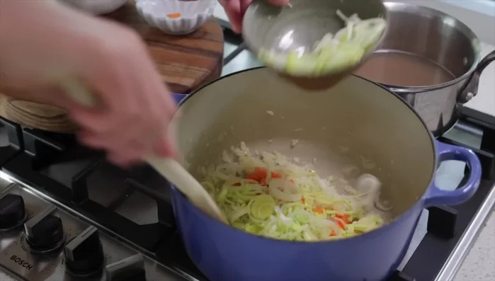 Ajouter les poireaux, carottes, fenouil, et thym. Faire suer pendant 4-5 minutes à feu moyen-doux.
