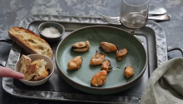 Servir chaud, avec des croûtons et des moules réservées comme garniture. Ajouter une touche de persil frais pour la décoration.