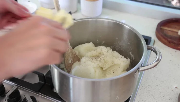 Ajouter le beurre, le poivre, le sel, et le fromage. Mélanger jusqu'à ce que le fromage soit fondu.