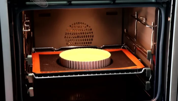 Cuisson à blanc : préchauffer le four à 160°C chaleur tournante, enfourner 18 minutes. Laisser refroidir 15 minutes, retirer le cercle et badigeonner d'œuf battu. Enfourner 8-10 minutes.