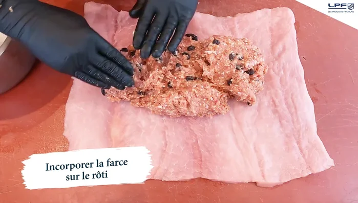 Étaler la farce à l'ail noir sur le rôti de porc.