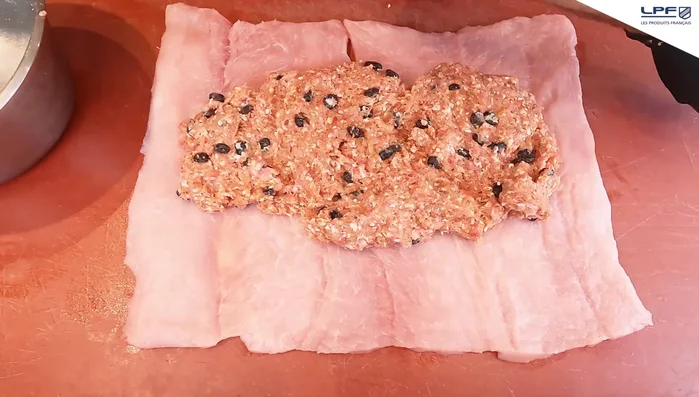 Aplatir la farce à l'aide d'un rouleau à pâtisserie pour obtenir une fine couche sur toute la surface du rôti.
