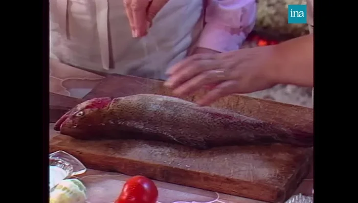 Préparer la truite: Saler, poivrer et farcir la truite avec des tomates coupées en morceaux, des champignons marinés au vinaigre, de l'ail émincé (sans germe), du citron vert et de la crème fraîche.