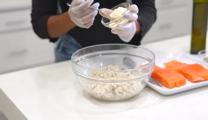 Assaisonner les crabes en morceaux avec de la mayonnaise, de la moutarde de Dijon, de l'oignon rouge, de la poudre d'oignon, de la poudre d'ail, de l'assaisonnement Cajun Crush, de l'assaisonnement créole et du jus de citron. Ne pas trop mélanger.