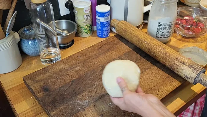 Fariner le plan de travail. Couper la pâte en deux. Former deux boules.