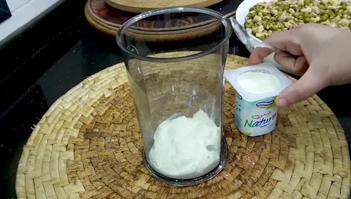 Préparer la sauce : mélanger dans un mixeur 2 boîtes de yaourt, du lait, 2 œufs, du fromage à pâte molle, du sel, du poivre et de l’alcool.