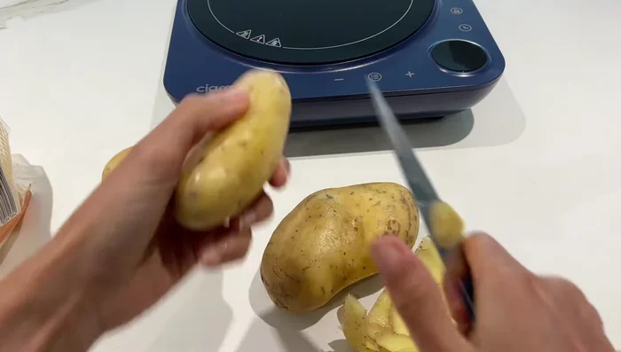 Préparation des frites : éplucher les pommes de terre, les laver et les couper en frites. Les plonger dans de l'eau froide pendant au moins 30 minutes (idéalement toute une nuit).