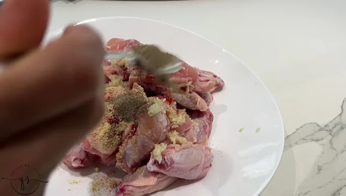 Mélanger les épices (paprika, gingembre, poivre, curcuma, sel, persil, coriandre) avec les ailes de poulet.