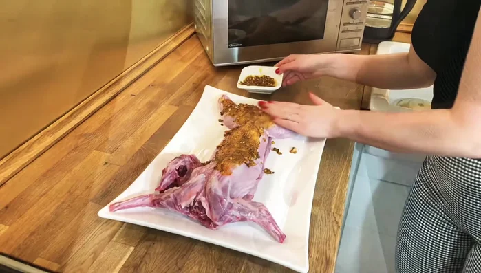Mariner le lapin: Frotter généreusement la marinade sur tout le lapin, en veillant à bien imprégner la viande (185.76).
