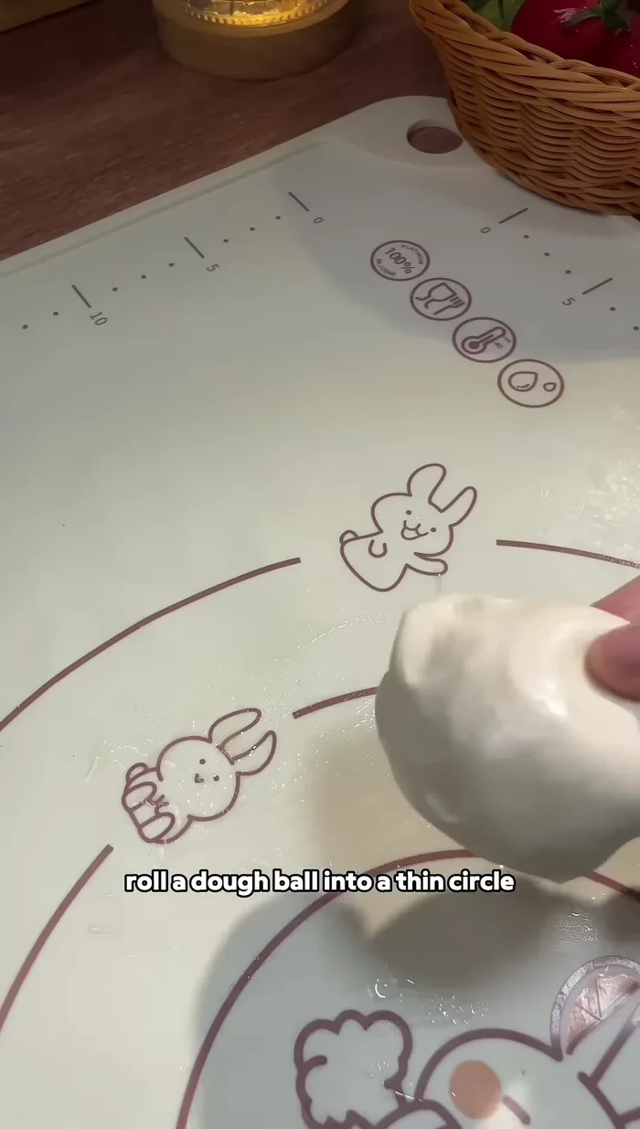 Roulez une boule de pâte en un cercle fin, étalez la pâte à l'huile et saupoudrez d'oignons verts.