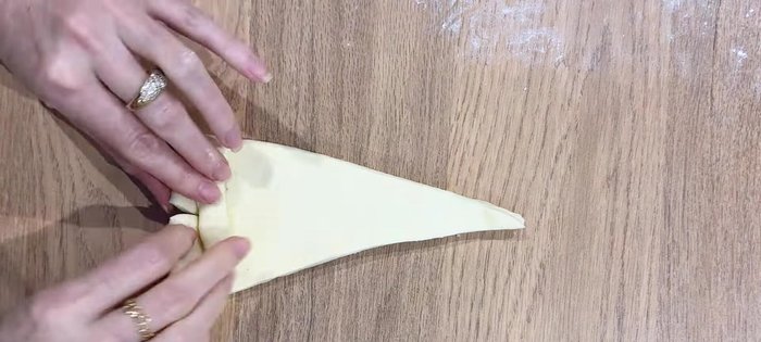 Former les croffles : Faire une fente sur chaque triangle, ajouter un petit morceau de pâte et replier.