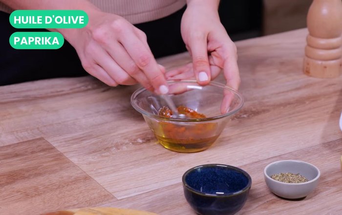 Préparation de la marinade : mélanger l'huile d'olive, le paprika, les herbes de Provence, le sel et le poivre.