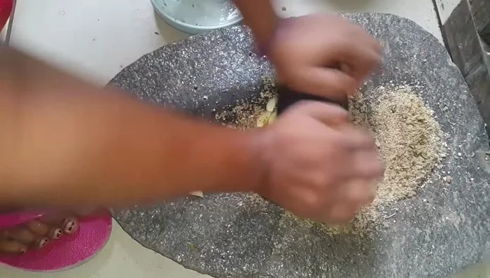 Écraser les épices (piment, ail, etc.) à la pierre ou au mortier. (304.759)