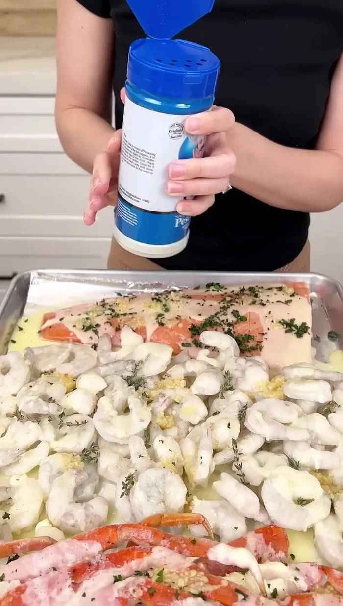 Mettre de l'assaisonnement pour poisson sur le saumon et les pattes de crabe.