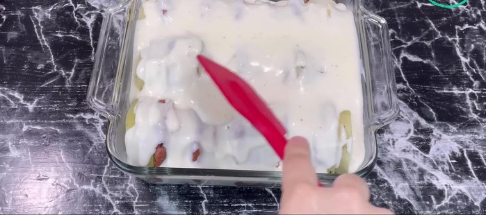 Verser la béchamel sur le gratin. Parsemer généreusement de fromage râpé.