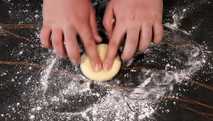 Diviser la pâte en 12 pâtons (65g chacun). Former des boules, creuser un puits au centre avec un verre. (469.08)