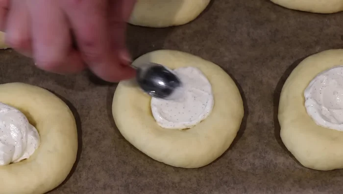 Déposer une cuillerée de crème au fromage dans chaque brioche, puis la compotée de fraises. Dorer avec de l’œuf battu. (512.039)