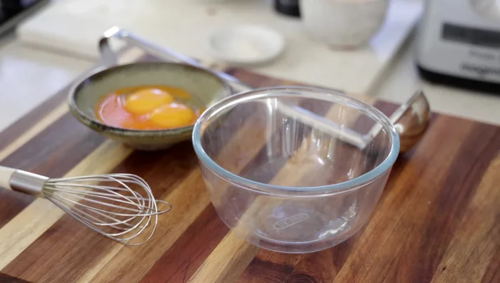 Méthode en un seul pot pour la crème anglaise: Dans un bol, mélanger les jaunes d'œufs restants avec une partie du lait chaud. Verser ce mélange dans la casserole contenant le lait, la crème et le sucre.