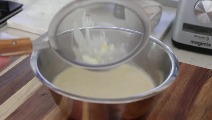 Tamiser la crème anglaise: Passer la crème anglaise au tamis pour éliminer les éventuels morceaux d'œufs.