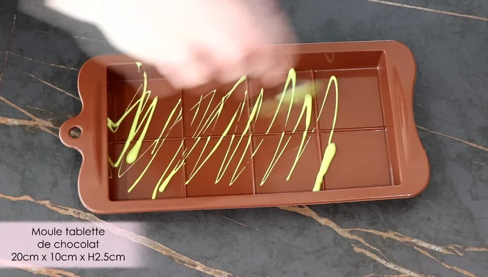 Dans le moule à tablette, faire des traits et des pois avec les chocolats colorés.
