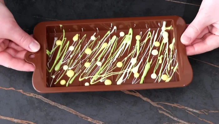 Taper légèrement le moule et réserver au congélateur pour que le chocolat fige.
