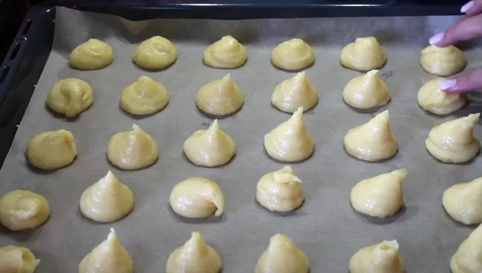 Aplatir les pointes des choux avec un doigt mouillé.
