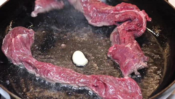 Faire cuire l'onglet dans une poêle avec de l'huile neutre et une gousse d'ail pendant 3-4 minutes de chaque côté. (77.75)
